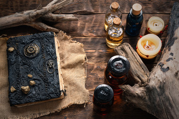 Magic book and a magic potions on a table. Witchcraft concept background. Druid or witch doctor...