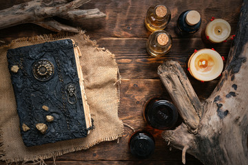 Magic book and a magic potions on a table. Witchcraft concept background. Druid or witch doctor...