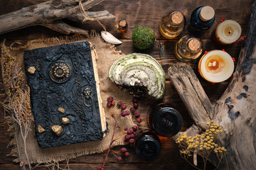 Magic book and a magic potions on a table. Witchcraft concept background. Druid or witch doctor...