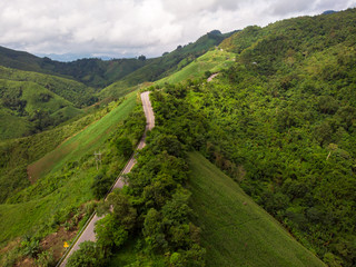 Aerial view Road on the top of a hill with lush greenery The atmosphere of the morning with fog Suitable for driving holiday travel.