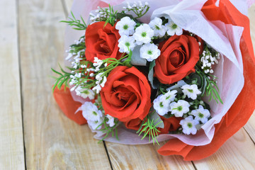 Red roses bouquet put on wooden background.