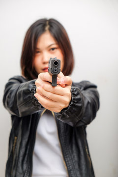Black shirt women aiming gun to audience on white background