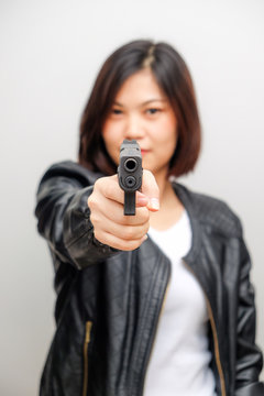 Black shirt women aiming gun to audience on white background
