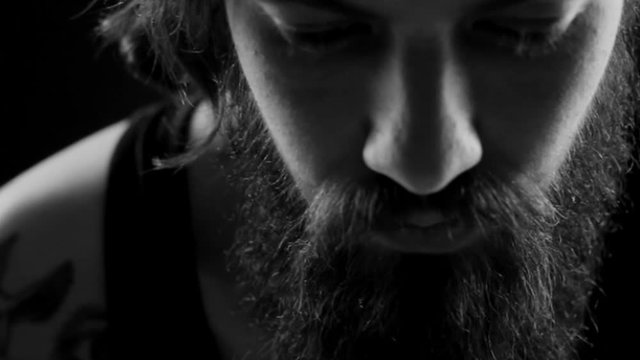 black and white video of young man with tattoo and beard. film