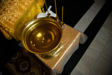 Font for baptism in the Orthodox Church. Symbols of Christianity inside the temple.