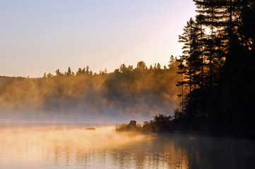 Sunrise and mist in beautiful lake in Algonquin Park