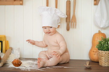 little plus size fatty baker child in chef hat at kitchen table alone