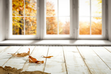 White wooden desk and autumn window space 