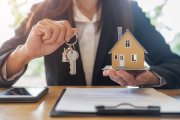 House model with agent and customer discussing for contract to buy, get insurance or loan real...