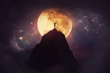 Deurstickers Volle maan Self overcome concept as a person raising hands up on the top of a mountain over full moon night background. Conquering obstacles, success achieving. Road to win, freedom symbol.