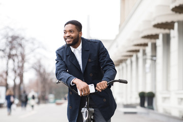 African american man in suit riding on bike to work