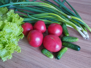 vegetables: tomatoes, cucumbers, onion salad on a wooden table