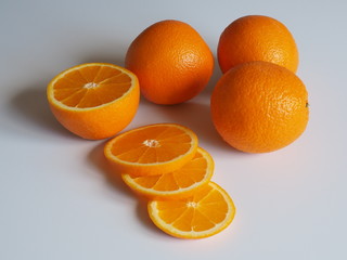 oranges on a light background whole and chopped