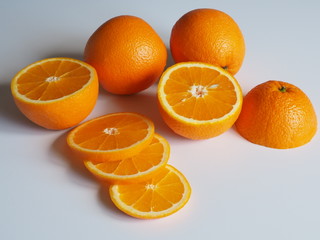 oranges on a light background whole and chopped