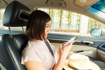Young asian women use smartphone in car while travel