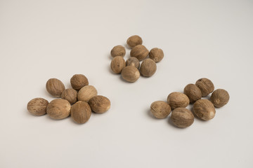 Loose nutmeg on a white plate and plate