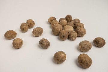 Loose nutmeg on a white plate and plate