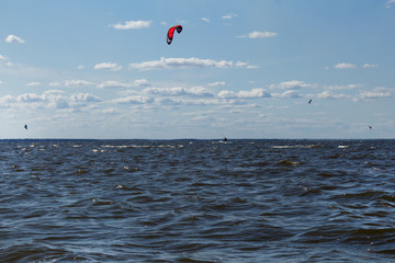 Kite boarding - athletes competition at sea on a summer day