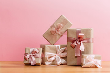 set of beautiful different gift boxes made by handmade with pink bows on a wooden table with a pink background. flat lay