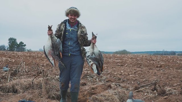 hunter with dead geese. Extraction. Goose Hunter. hunting trophy