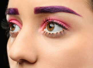 Young woman with dyed eyebrows and creative makeup, closeup