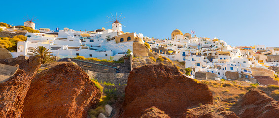 Handheld view of the coastal cliffs of Santorini as seen from a boat on the water.