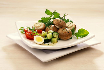 Plated Egg and Brown Mushroom Salad on white wood background