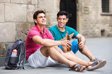 glad male fans are drinking beer and talking about football outdoor in Barcelona