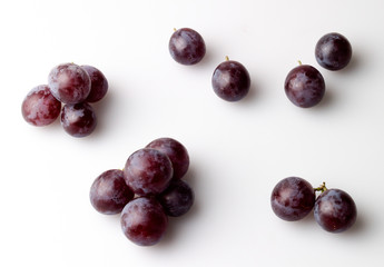 Study of red grapes with bloom against white