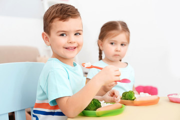 Cute little children eating lunch in kindergarten