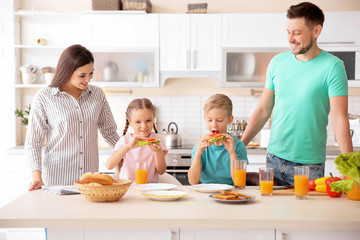 Happy family having breakfast with toasts in kitchen