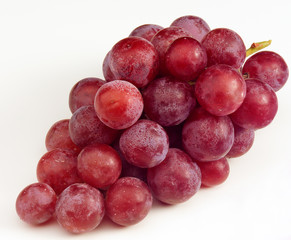 Bunch of red Grapes with bloom against a white background