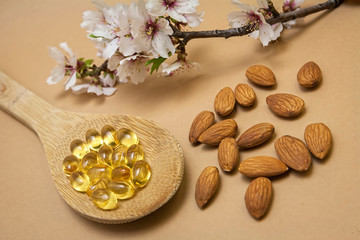 Obraz na płótnie Canvas Almond oil in capsules isolated on brown background