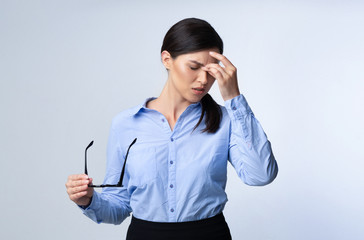 Tired Business Girl Massaging Nosebridge Having Migraine In Studio