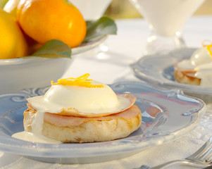 Eggs Benedict with Ham and toasted muffin in a table settting