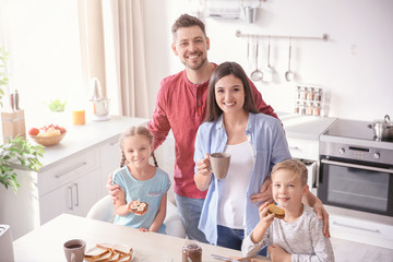 Obraz na płótnie Canvas Happy family having breakfast with toasts in kitchen