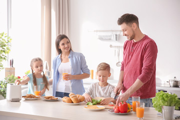 Obraz na płótnie Canvas Happy family having breakfast with toasts in kitchen