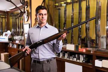 Man owner of hunting store  standing with shotgun