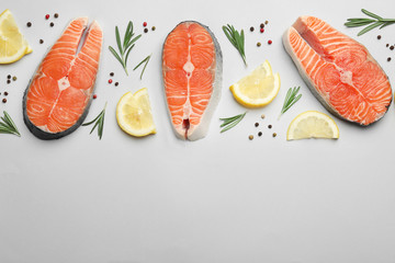 Flat lay composition with salmon steaks on white background. Space for text