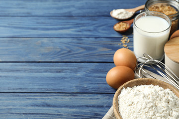 Fresh ingredients for delicious homemade cake on blue wooden table. Space for text