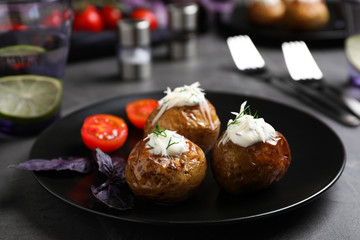 Delicious hot baked potato with sour cream dressing on grey table