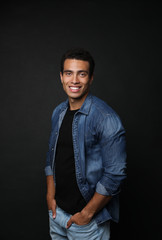 Handsome young African-American man on black background