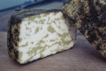 Craft cheese from cows and goats milk. Cheese head. Selective focus