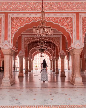 Rear view of woman walking through ornate arched colonnade
