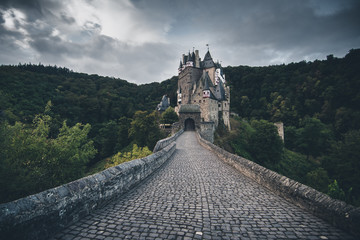 An old stone castle at the end of  a coblestone road