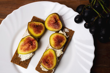 Homemade wheaten bread sliced and topped with cream cheese and fresh figs