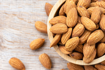 Almond seeds in a wooden cup By resting on a wooden table
