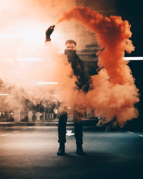 Man holding smoke flare in garage