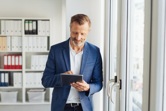 Stylish businessman using a handheld tablet-pc