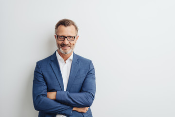 Friendly businessman posing with folded arms